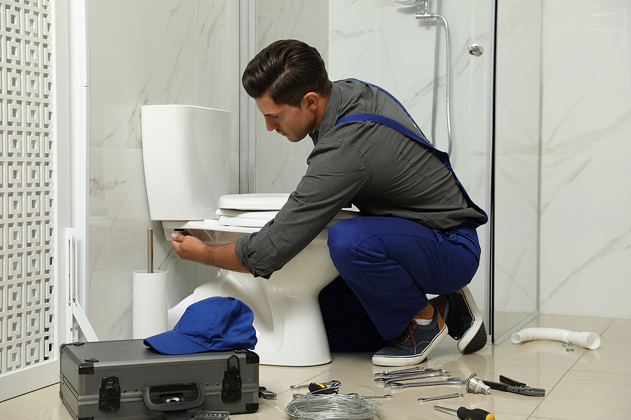 Plumber fixing a toilet issue after hours